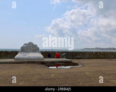 Lowestoft, Suffolk - 19. Juni 2023 : Angeln am Pier neben dem Fischerdenkmal. Stockfoto