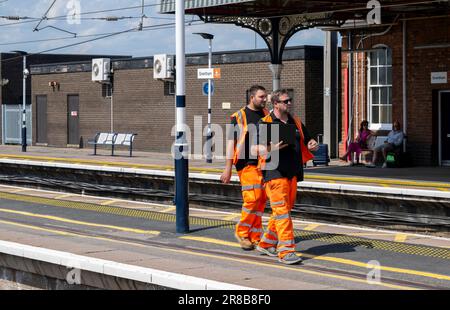 Bahnhof Grantham – Eisenbahningenieure oder Wartungspersonal, die einen Bahnsteig entlang laufen Stockfoto