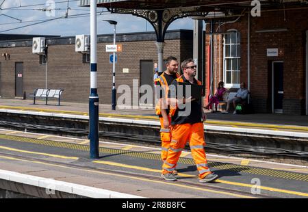 Bahnhof Grantham – Eisenbahningenieure oder Wartungspersonal, die einen Bahnsteig entlang laufen Stockfoto