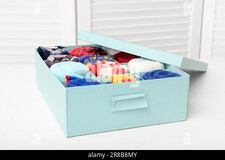 Box mit verschiedenen Socken auf dem Lichttisch Stockfoto
