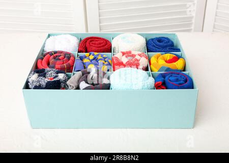 Box mit verschiedenen Socken auf dem Lichttisch Stockfoto