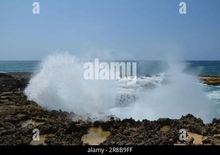 Große Wellen brechen und planschen an der Küste der Insel Aruba Stockfoto