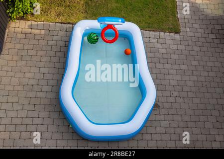 Wunderschöner Blick von oben auf den aufblasbaren Kinderpool mit Wasser auf dem Vorgarten im Garten der Villa. Schweden. Stockfoto