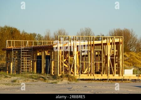 Neuer, unfertiger Rahmen für ein natürliches Holzcafe-Gebäude und Terrassenboden an der Ostsee, blauer Himmel im Hintergrund Stockfoto