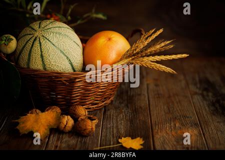 Herbststille mit Melone im dunklen Schlüssel auf Holzhintergrund Stockfoto