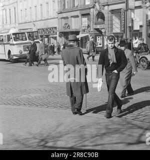 Strom 17-5-1960: Helfen Sie Blind. Tag und Nacht in ewiger Dunkelheit. Nur wenn das Sonnenlicht besonders stark ist, weiß er, was Licht ist. Dann flackert es irgendwo im Hinterkopf. Unangenehm, ohne Erfolg. Deshalb trägt er eine schwarze Brille, Bjørn Myrberg, einer der 4.000 Norweger, die nicht sehen können, einer von denen, die unsere Hilfe brauchen. Gibst du ihm einen anstrengenden Tag im Verkehr? Hilflos zurück Er wartet seit 4 Minuten. Die Leute haben die Straße mehrmals überquert. Beschäftigte Leute. Selbstsüchtige Menschen. Der Mann, der sich zurückhält, ist blind. Foto: Aage Storløkken / Aktuell / NTB ** Stockfoto