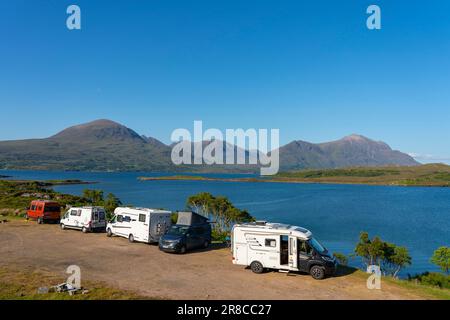 Touristenmotorhäuser und Wohnmobile, die neben Loch Torridon in den schottischen Highlands an der North Coast 500 Road Trip, Schottland, Großbritannien, geparkt haben Stockfoto