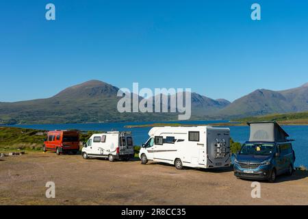 Touristenmotorhäuser und Wohnmobile, die neben Loch Torridon in den schottischen Highlands an der North Coast 500 Road Trip, Schottland, Großbritannien, geparkt haben Stockfoto