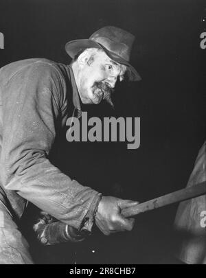 Derzeit 17-1950: Industrie in der WastelandBetween schneebedeckte Berge an der schwedischen Grenze, weit östlich von Bodø, liegt Sulitjelma. Die Menschen in dieser Bergstadt sind völlig abhängig vom Bergbau und den Minen. Die Kommunikation ist schlecht. Im Frühjahr und Herbst kann Sulitjelma vollständig von der Außenwelt isoliert werden. Die 3.000 Menschen, die dort leben, sind alle "de" und leben ihr eigenes Leben - fast wie ein Staat innerhalb eines Staates. Tief in der Mine auf Jakobsbakken trafen wir Peder Misvær - einen alten und erfahrenen Bergarbeiter, der nicht den großartigen Schnurrbart opfern wollte, den er als Mann trug Stockfoto