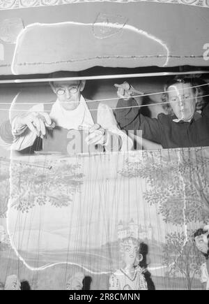 Tatsächlich 01-1947: Das Puppentheater die Kinder erobern die Theater zu Weihnachten, Kindershows werden oft im ganzen Land aufgeführt. Aktuell hat 'eineinhalb Stunden mit dem Weihnachtsmann' im Studioteatret in Oslo besucht. Das Rönnblad-Paar, das das gesamte Theater mit insgesamt 300 Puppen leitet, hat in schwedischen Grundschulen mehr als 5.000 Auftritte gegeben, und jedes Jahr werden die Auftritte von über 60.000 Kindern gesehen. Hinter den Kulissen des Spiels. Es erfordert Geschicklichkeit und Training, um alle Fäden meistern zu können, damit Sie immer die richtige ziehen. Foto: Aktuell / Stockfoto