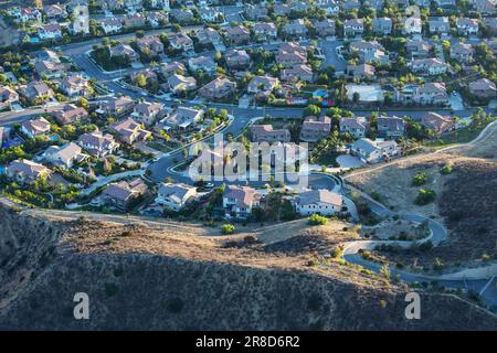 Am späten Nachmittag können Sie die auf einem Hügel gelegenen Vorstadthäuser in der Nähe von Los Angeles in Simi Valley, Kalifornien, aus der Vogelperspektive bewundern. Stockfoto