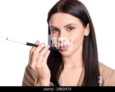 Frau, die einen langen Zigarettenhalter zum Rauchen benutzt, isoliert auf Weiß Stockfoto