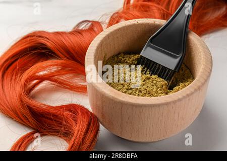 Hennapulver, Pinsel und roter Strang auf weißem Tisch, Nahaufnahme. Natürliche Haarfarbe Stockfoto