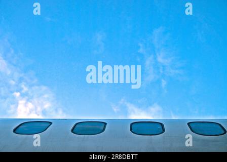 fenster eines Flugzeugteils von Rumpf und Himmel Stockfoto