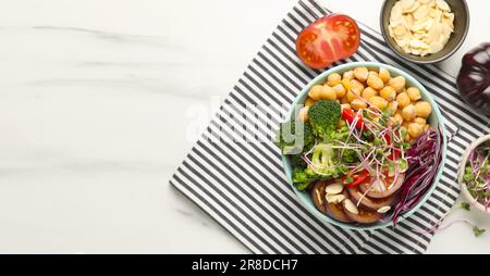 Köstliche vegane Schüssel mit Brokkoli, Rotkohl und Kichererbse auf weißem Marmortisch, flach liegend. Bannerdesign mit Platz für Text Stockfoto