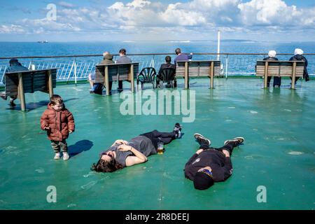 Ein kleines Kind beobachtet zwei schlafende Passagiere an Bord Einer DFDS Cross Channel Ferry vor der Sussex Coast, Großbritannien. Stockfoto