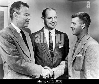 Vereinigte Staaten: c. 1958. Ein junger Mann wird von einem älteren Mann im Anzug begrüßt. Stockfoto