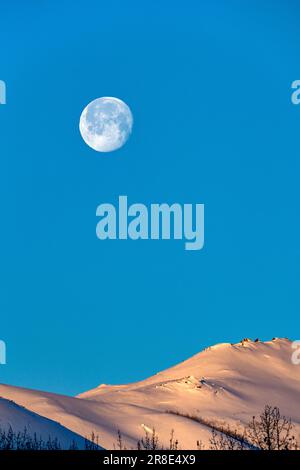 USA, Idaho, Sun Valley, Vollmond über schneebedeckten Hügeln Stockfoto