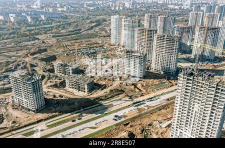 Große Baustelle mit Kränen, Baumaschinen und Wohngebäuden im Bau. Draufsicht. Stockfoto