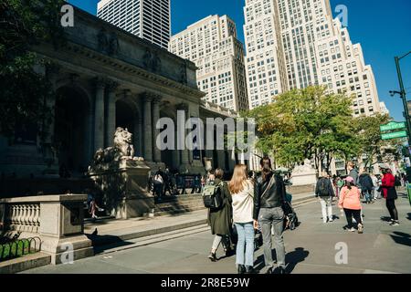 Geschäftige Straßenszene in New York City mit Gruppen von Personen, die über eine überfüllte Kreuzung auf der Fifth Avenue in Midtown Manhattan, NYC, laufen. Hohe Qualität Stockfoto