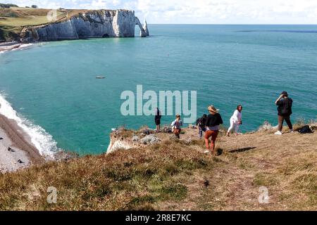 ETRETAT, FRANKREICH - 1. SEPTEMBER 2019: Unbekannte Touristen bewundern den Blick auf den Stadtstrand und den Rock d'Aval von den umliegenden Hügeln. Stockfoto