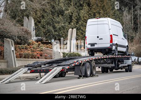 Industriestandard flaches Fahrerhausprofil Weißer LKW-Transporter lieferte Fracht-Minivan auf hydraulischem Auflieger, der diesen Van auf dem entlädt Stockfoto