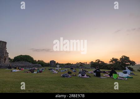Hadleigh Castle, Großbritannien. Juni 2023. Die Teilnehmer treffen sich auf Yogamatten für eine ruhige Outdoor-Session in der Nähe der historischen Ruinen von Hadleigh Castle, Essex, während der Sommersonnenaufgang. Der klare Himmel und das warme Licht schaffen eine ruhige Umgebung für kollektive Achtsamkeit und Reflexion. Eine Gruppe übt Yoga, während die Sonne zur Sommersonnenwende an den Ruinen der Burg in der Stadt aufgeht. Penelope Barritt/Alamy Live News Stockfoto