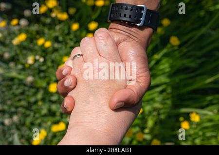 Weiße weiße weiße und schwarze afroamerikanische Hände halten zusammen, Liebe und Vielfalt Konzept. Schwarze männliche und weiße weibliche Hände, die die Handflächen berühren Stockfoto