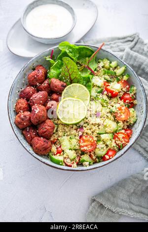 Buddha-Schüssel mit Rote-Bete-Falafel-Kugeln und Zitronenjoghurt-Dip. Tabbouleh-Salat. Levantinvegetarischer Salat. Stockfoto