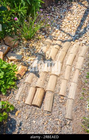 Gartenweg aus natürlichen Holzplanken, Steinen, Kies. Gesunder sensorischer Pfad mit verschiedenen Oberflächen. Stockfoto
