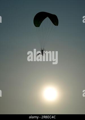 Ein Mann fliegt einen Paramotor über Crosby Beach, Merseyside, am Vorabend der Sommersonnenwende. Foto: Dienstag, 20. Juni 2023. Stockfoto