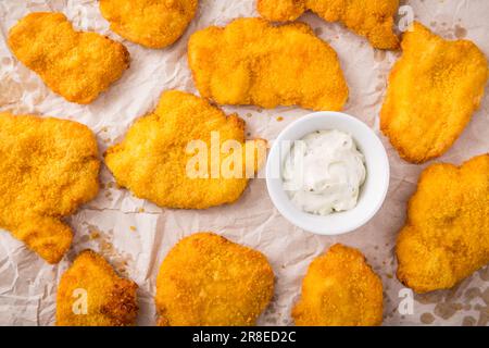 Kleines Hähnchenschnitzel auf Backblech mit Kräutermayonnaise Stockfoto