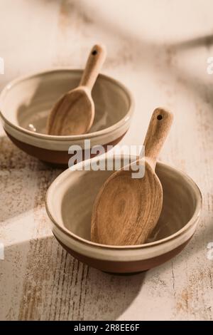 Zwei Steingut-Schüsseln mit Holzlöffel auf dem Küchentisch Stockfoto