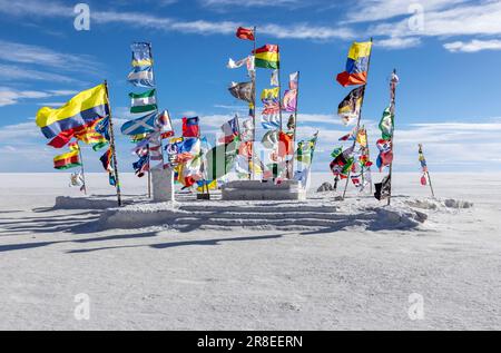 Farbenfrohe internationale Flaggen auf dem Salar de Uyuni in der Nähe des Monuments Rallye Dakar in Uyuni, Bolivien - Reisen und Erkunden des Altiplano Stockfoto