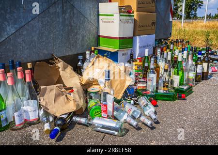Hockenheim, Deutschland - 18. Juni 2023: Überfüllte Glasbehälter auf einer Straße. Recycling-Konzept und Müllentsorgung. Übersetzung: Kommerzieller Dienst, Stockfoto