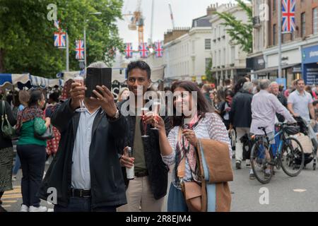 Asiatische Familiengruppe UK, machen Sie ein Selfie mit PlastikChampagne Picknick Gläsern. Die Kings Road, Platinum Jubilee Street Party. Chelsea, London, England 4. Juni 2022. 2020er Jahre HOMER SYKES Stockfoto
