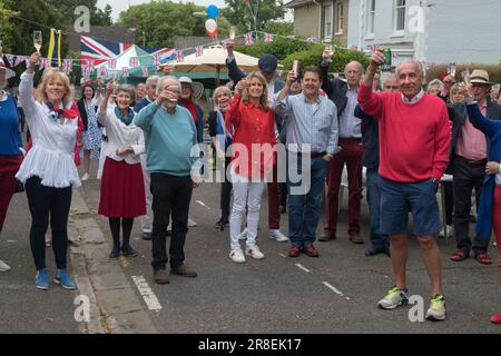 Treuer Toast Gott rette die Königin. Winchester, Hampshire, England, 5. Juni 2022. Queen Elizabeth II. Platinum Jubilee Straßenfest in der Grafton Road. Die Straße war geschlossen, mit Fähnchen dekoriert. Die Anwohner wurden ermutigt, rot, weiß und blau zu tragen. Um 12 Uhr gab es einen lokalen Toast und drei Anfeuerungen für die Königin und dann das Singen der Nationalhymne. HOMER SYKES AUS DEN 2020ER JAHREN Stockfoto