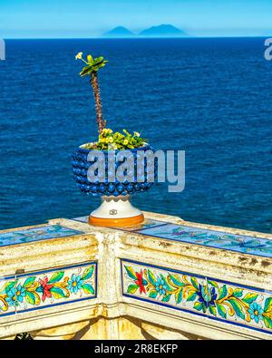 Geschnitzter Handlauf mit Keramikmuster und mit blauem Becken mit Kaktus in der Stadt Santo Stefano di Camastra Stockfoto