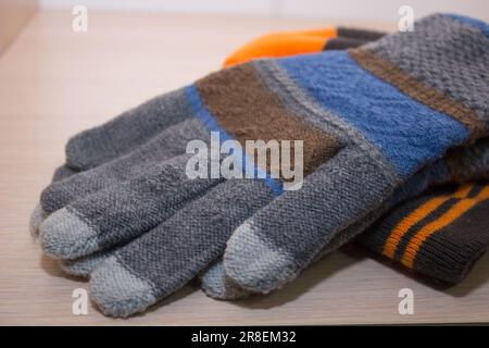 Handschuhe und Wintermütze liegen im Regal des Kleiderschranks Stockfoto