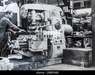 Junger Mann, der eine Fräsmaschine in Wallis und Steevens, Fabrik um 1950, Basingstoke, Hampshire, England, Großbritannien, betreibt Stockfoto