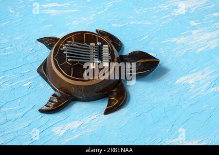 Kalimba-Schildkröte auf blauem Hintergrund. Traditionelles Instrument aus Afrika in Nahaufnahme. Stockfoto