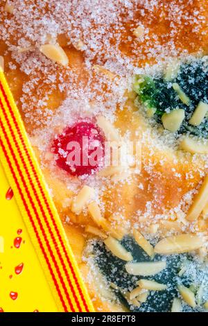 coca de Sant Joan. Brioix kandierter Früchte zur Feier von Sant Joan, mit einem Band der katalanischen Flagge. Vertikales Bild Stockfoto