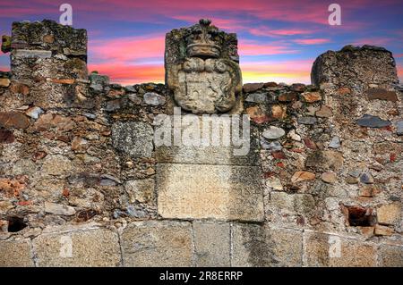 Ein malerischer Blick auf eine mittelalterliche Mauer, beleuchtet von einem goldenen Sonnenuntergang in der monumentalen Stadt Caceres Stockfoto