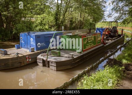 Arbeitsboote auf einem Kanal in Worcestershire, von denen eines mit einem Bagger ausgestattet ist, bereiten sich darauf vor, wichtige Arbeiten entlang der Wasserstraße durchzuführen. Canal & River Trust. Stockfoto