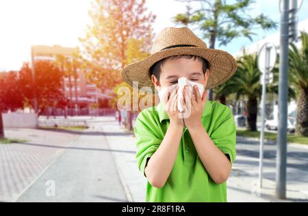 Kind bläst im Wischtuch leidet an Grippesymptomen auf der Straße. Stockfoto