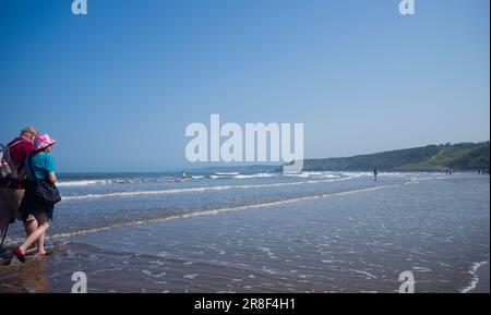 Ein älteres Paar, das in South Bay, Scarborough, in der Brandung spaziert Stockfoto