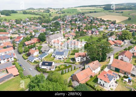 21. Juni 2023, Hessen, Ebersburg/Weyhers: Blick auf das Dorf während eines Dorfbesuchs der evaluierungskommission von "Unser Dorf hat eine Zukunft". (Luftfoto mit Drohne) Neben Entwicklungskonzepten bewertet der Wettbewerb des Bundesministeriums für Landwirtschaft wirtschaftliche, soziale, kulturelle und ökologische Aspekte, mit denen die Dorfgemeinschaften zu einem attraktiven Leben in ihren Dörfern beitragen und sie zukunftsfähig machen. Foto: Sebastian Christoph Gollnow/dpa Stockfoto