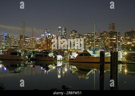 Beleuchtete Wolkenkratzer und Vergnügungsboote spiegeln sich im ruhigen Wasser, Stanley Park, Nachtaufnahme, Vancouver Downtown, British Columbia, Kanada Stockfoto