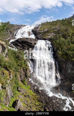 Wanderung am Wasserfall im Husedalen Valley in Norwegen an einem sonnigen Sommertag. Wasserfluss aus Hardangervidda, der mehrere Wasserfälle verursacht. Stockfoto