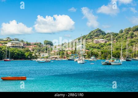 Türkisfarbenes Meer mit angehängten Yachten und Booten in der Lagune auf der Insel Carriacou, Grenada, Karibik Stockfoto